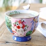 Taza de porcelana de Frida Kahlo con loro blanco sobre el asa.