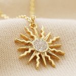 Collar de sol dorado con cristales blancos